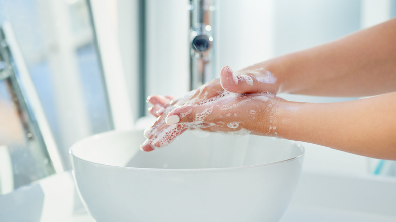 A person washing their hands with soap and water