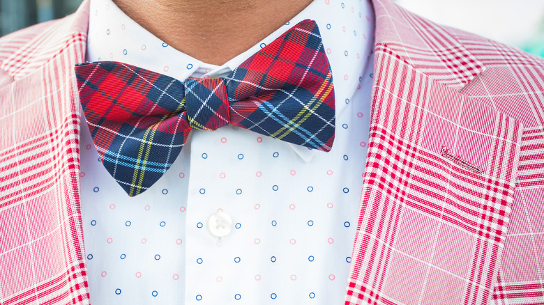 Man wearing plaid bow tie and pink plaid blazer