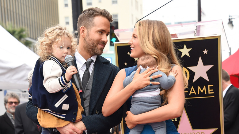 Blake Lively holding her newborn while Ryan Reynolds holding James