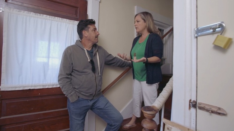 Jonathan Knight and Kristina Crestin talking on a staircase in "Farmhouse Fixer"