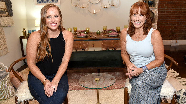 Mina Starsiak Hawk and Karen Laine smiling with a table separating them