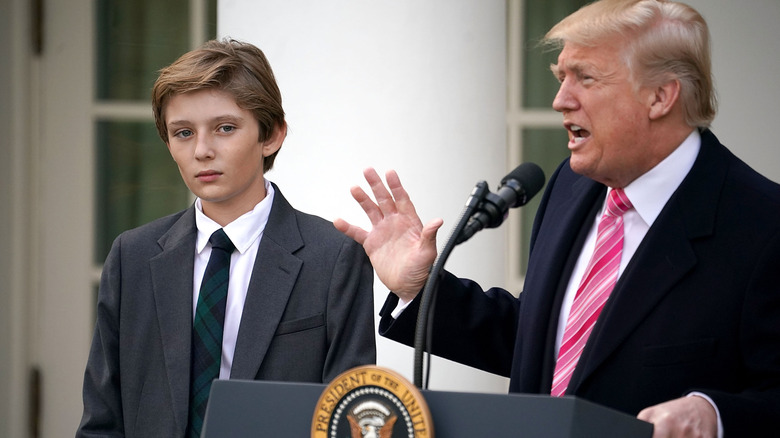 Young Barron Trump standing at Donald Trump's side as he delivers a speech