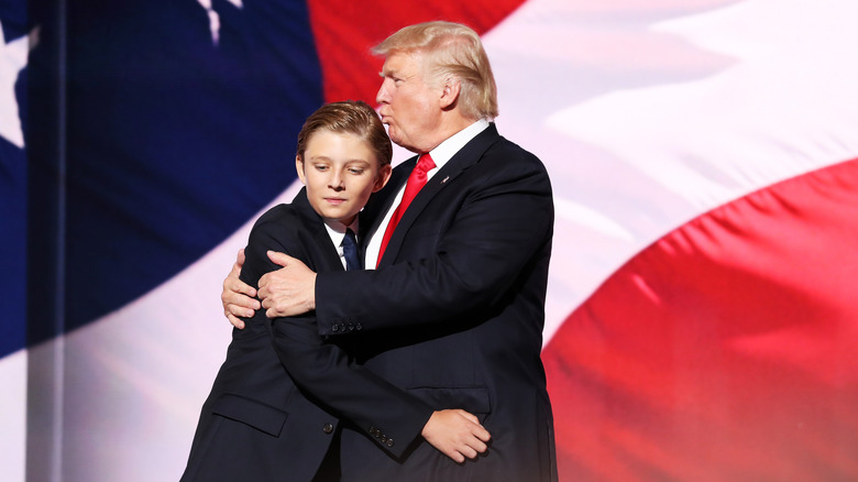 Donald Trump trying and failing to kiss the top of Barron Trump's head on stage