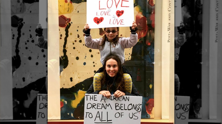 Jordin Ruderman and her daughter holding signs