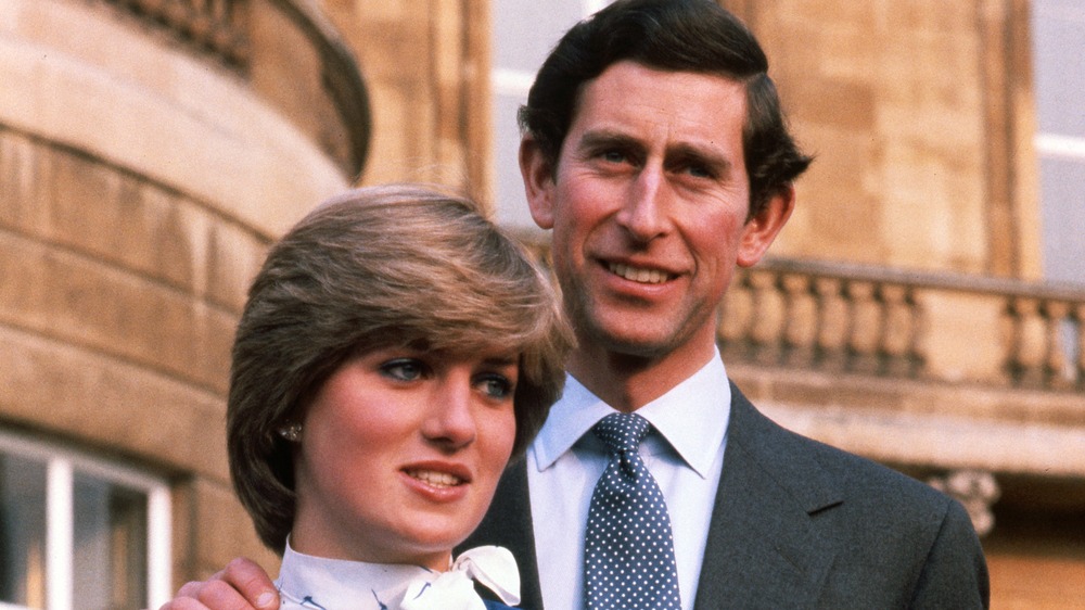 Prince Charles standing behind Princess Diana