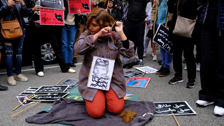 woman cutting hair at protest