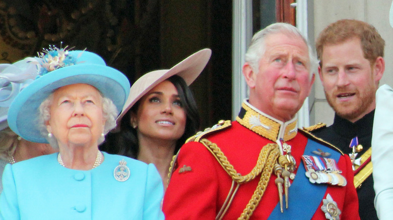 Prince Harry, Prince Charles, Queen Elizabeth, and Meghan Markle posing 