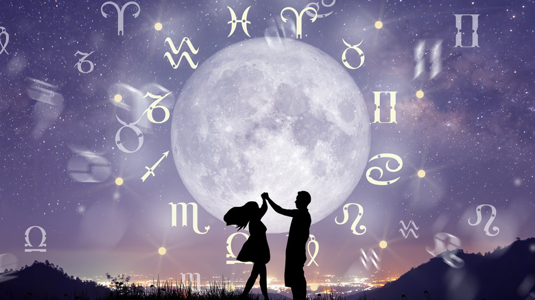 Astrological zodiac signs inside of horoscope circle. Couple singing and dancing over the zodiac wheel and milky way background