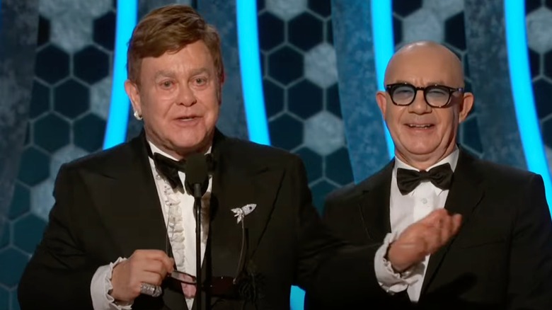 Elton John and Bernie Taupin speaking at podium