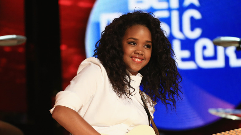 H.E.R. playing guitar