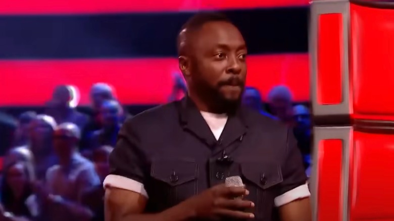 will.i.am holding a microphone onstage