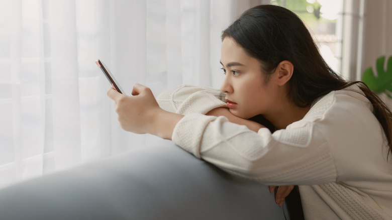 Woman looking frustrated at phone