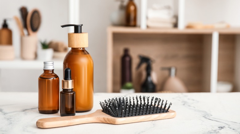 Brown cosmetics bottle and hairbrush on counter