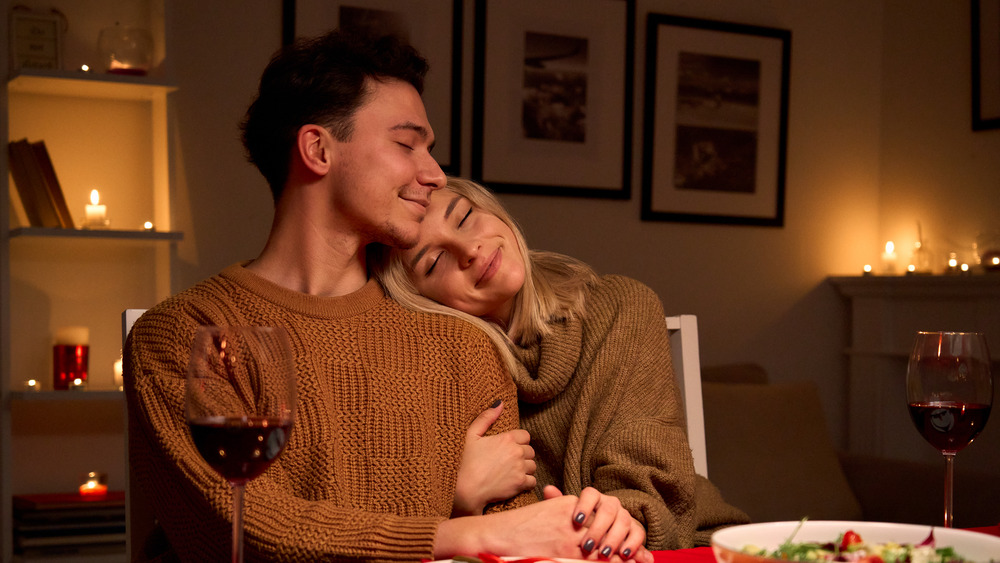 Partners cuddling at dinner table