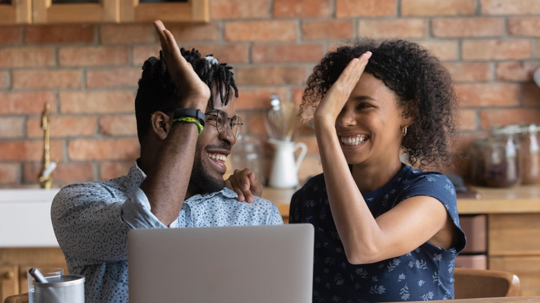 Man and woman high-fiving