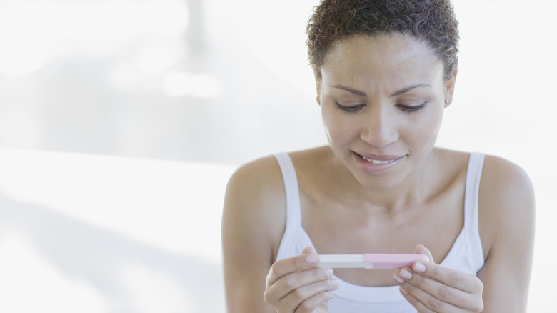 Woman studying pregnancy test 