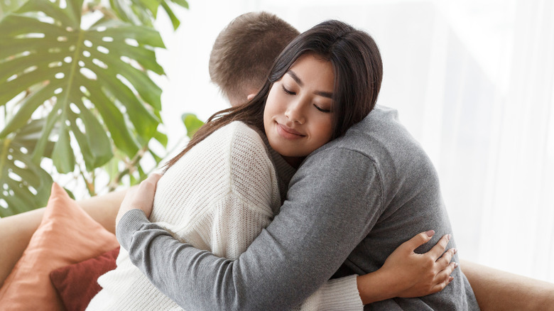 A woman and man hug 