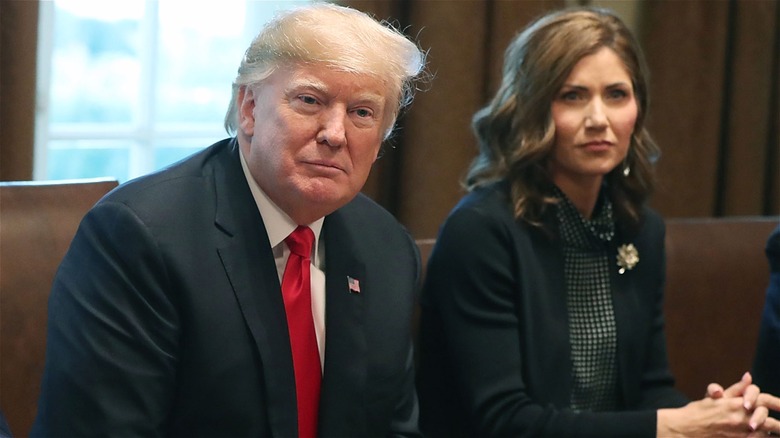 Trump and Noem sitting at conference table