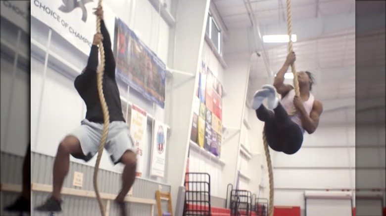 Simone Biles and Jonathan Owens climbing ropes 