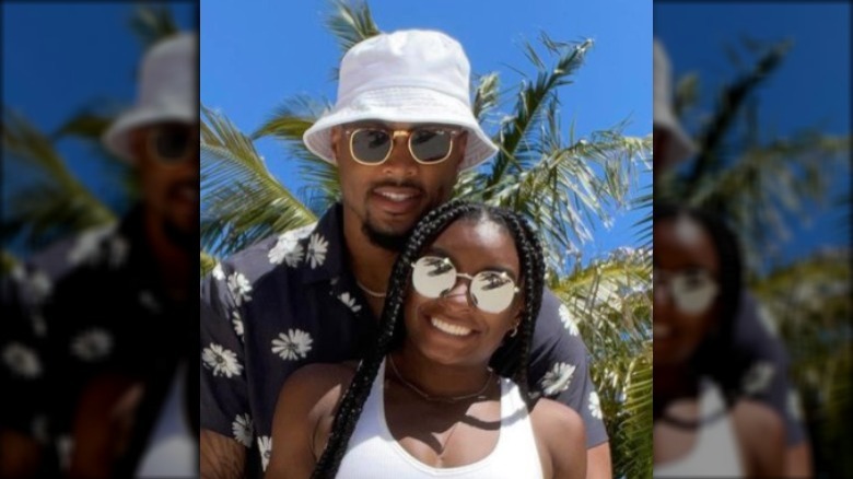 Simone Biles and Jonathan Owens in front of a palm tree