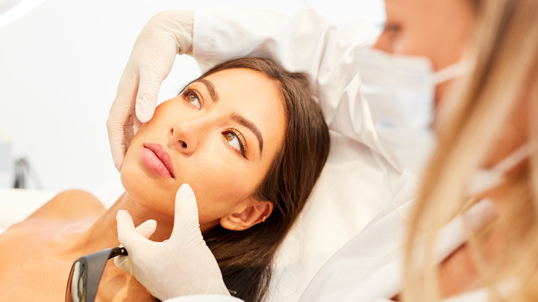 Doctor touching woman's face