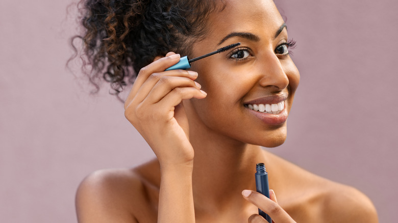 Woman smiling applying mascara