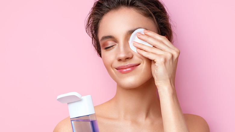 woman using makeup remover for eye makeup