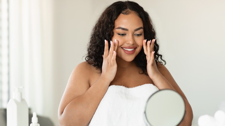 Woman doing makeup in mirror