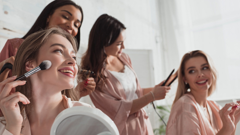 Bride doing makeup with bridesmaids