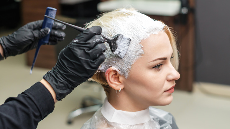 A woman getting her hair bleached blonde