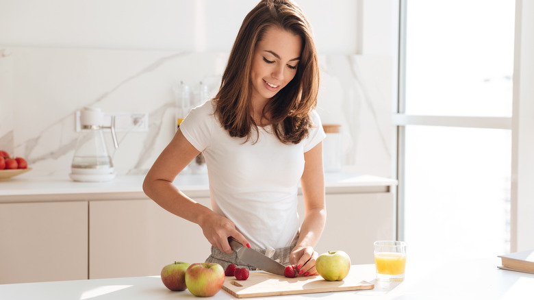 Woman cutting fruits in the kitchen