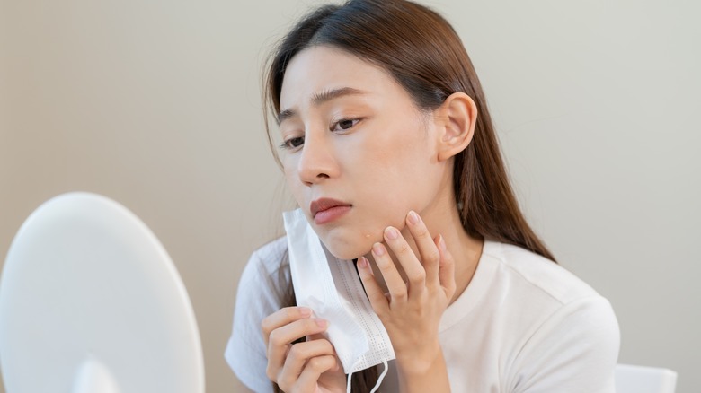 A woman inspecting her skin