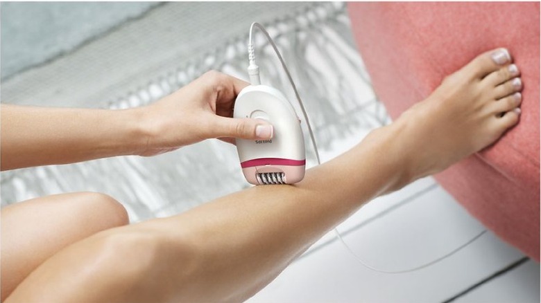 woman using corded epilator