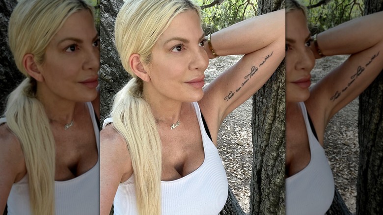 Tori Spelling leaning against a tree selfie