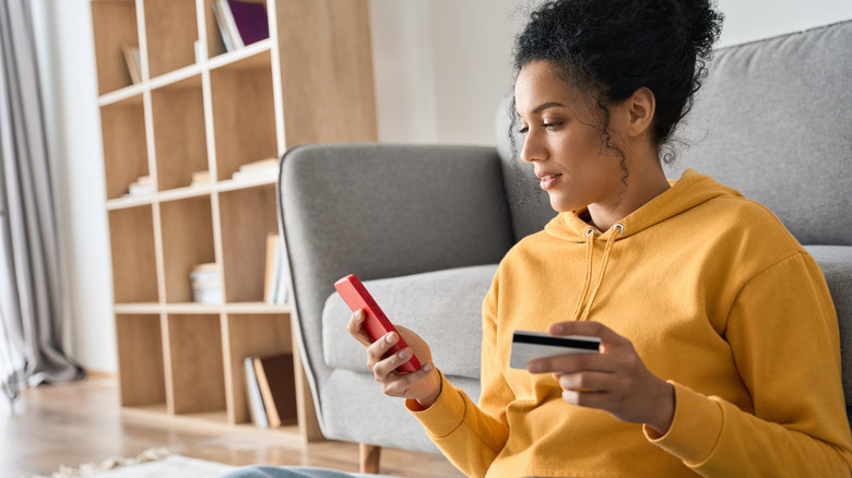 Woman holding debit card and phone 