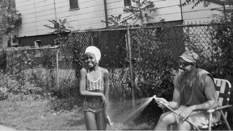 MIchelle Obama smiling and Fraser Robinson smiling and spraying her with a hose