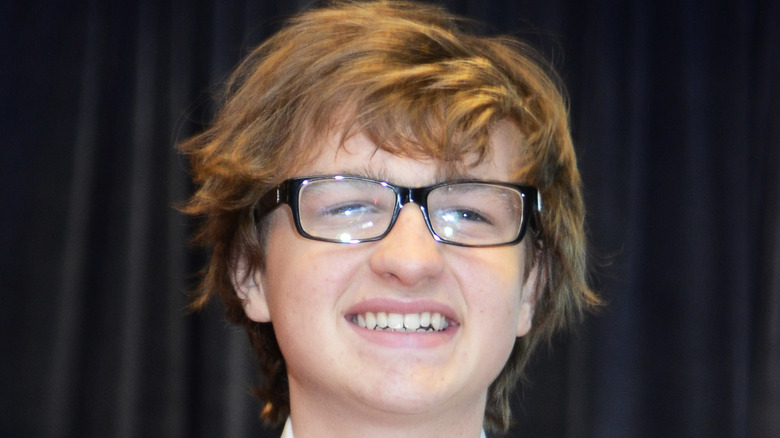 Angus T. Jones smiles at an event