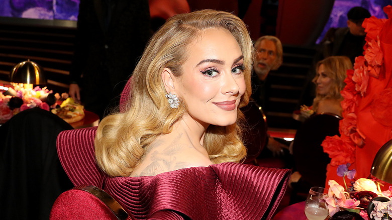 Adele posing at a table