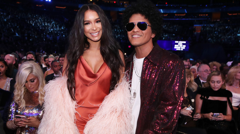 Bruno Mars and Jessica Caban smiling for photos at the Grammys