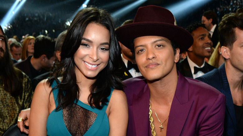 Bruno Mars sitting with his arm around Jessica Caban