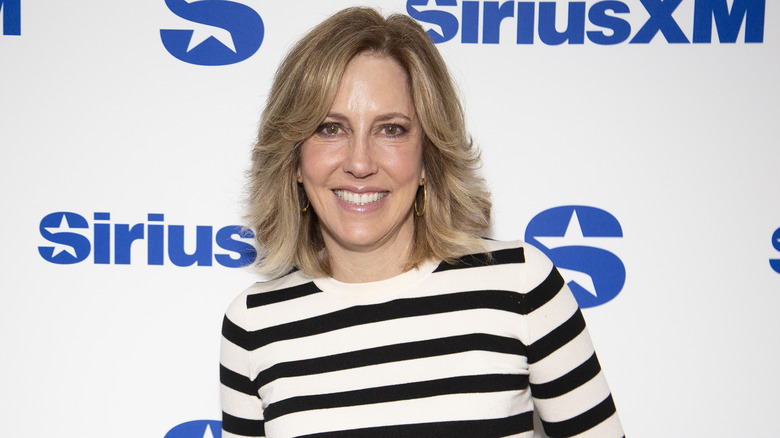 Alisyn Camerota stands in front of a SiriusXm banner