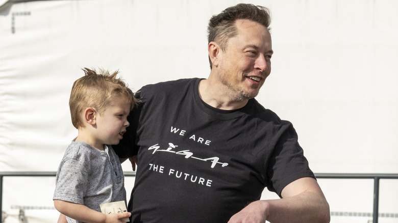 Elon Musk holding son