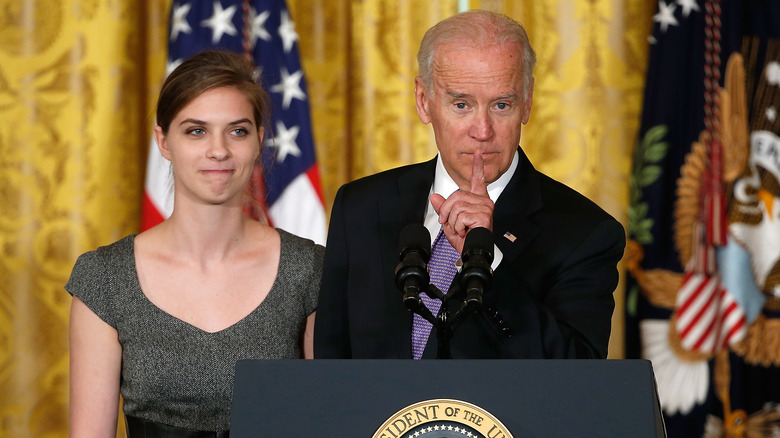 Lilly Jay standing behind President Joe Biden 