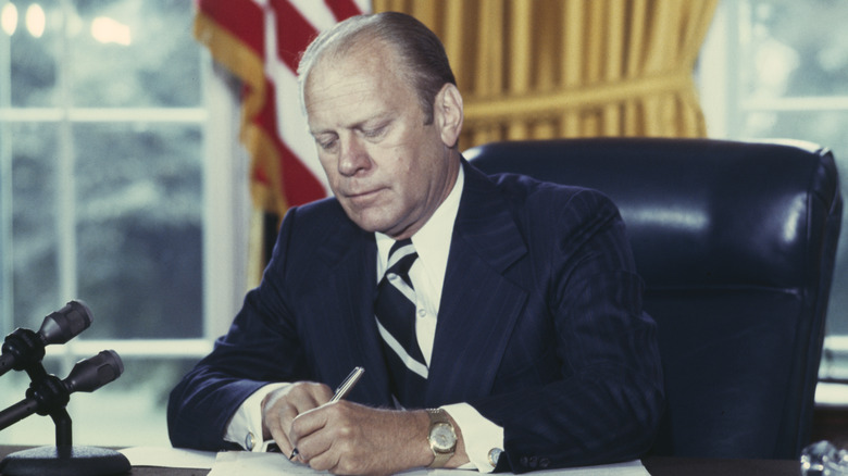 Gerald Ford signs a pardon for Richard Nixon, 1974