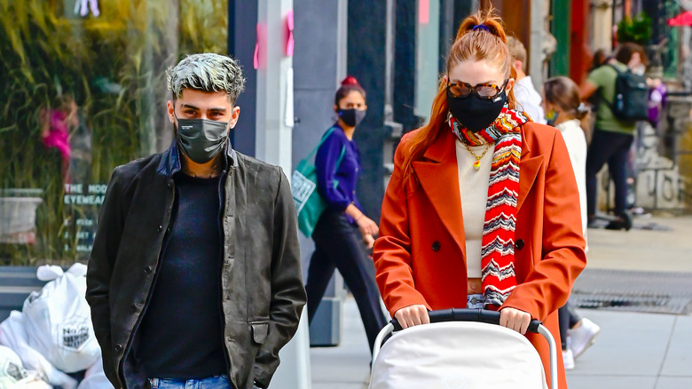 Gigi Hadid and Zayn Malik walking with their daughter