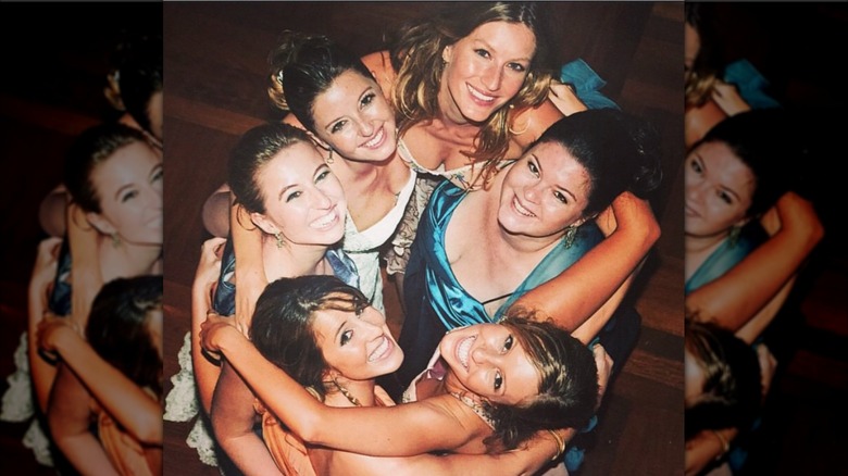 Gisele Bündchen looks up at the camera with her five sisters as they all embrace