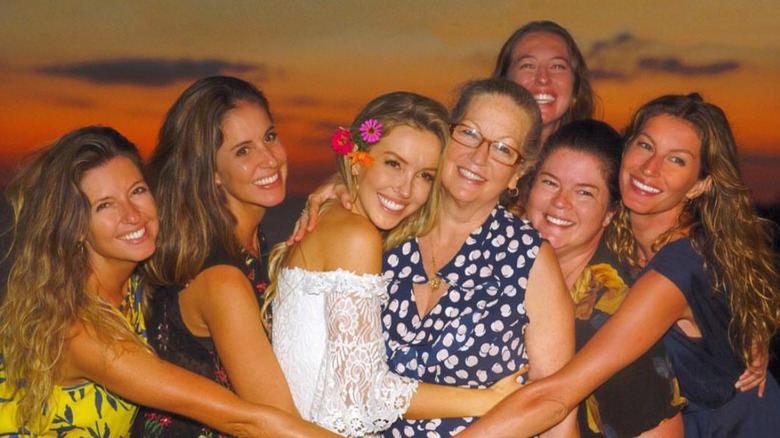 Gisele Bündchen smiles with her mother and five sisters in front of a sunset