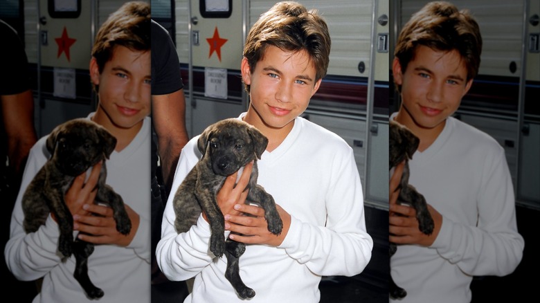 Jonathan Taylor Thomas smiling with a puppy