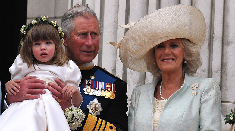 King Charles holding granddaughter Eliza Lopes, next to Queen Camilla