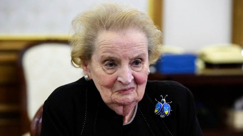 Madeline Albright smiling and wearing an ornate pin